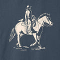 Close-up of the cream-colored cowgirl and horse illustration printed on the Vintage Navy Dust & Reins Tee.
