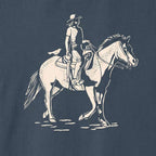 Close-up of the cream-colored cowgirl and horse illustration printed on the Vintage Navy Dust & Reins Tee.