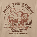 Close-up of a beige fabric surface with a distressed brown graphic print featuring a bison, the words “FACE THE STORM,” and smaller text reading “BUILT TO WEATHER IT” and “LOST DRAW PROVISIONS.”.