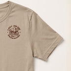 A close-up of a beige short-sleeve t-shirt featuring a brown circular graphic on the left chest with a bison and the text 'LOST DRAW PROVISIONS'.