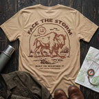 Tan Face the Storm buffalo graphic tee displayed with hiking boots, a canvas jacket, and vintage outdoor accessories.