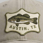 Cap with a fish emblem and 'Austin, TX' text on a beige background