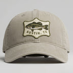 Beige cap with fish emblem and 'Austin, TX' text on a gray background