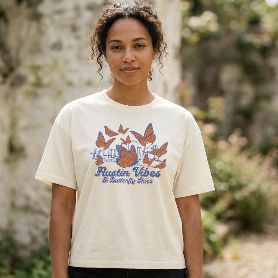 Woman wearing Butterfly Skies women’s boxy t-shirt with monarch butterflies and Austin skyline