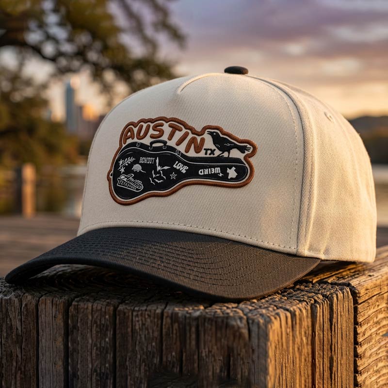 Cap with 'Austin, TX' logo on a wooden surface with a blurred background