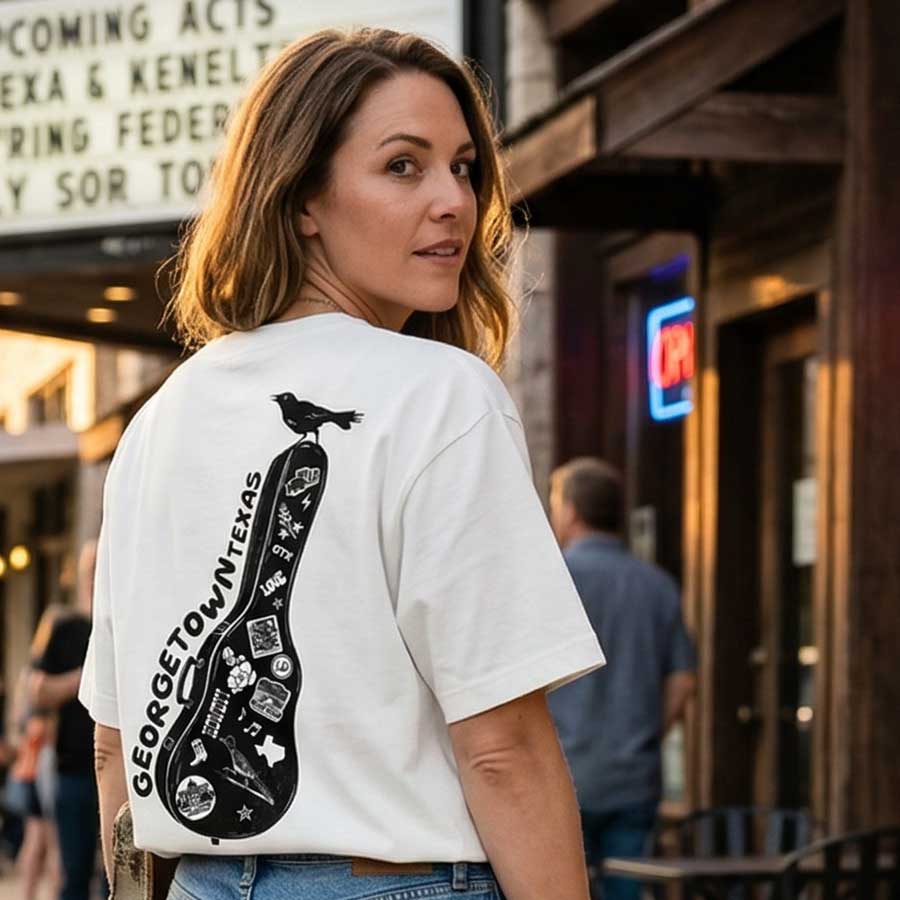 Woman wearing a heavyweight oversized Georgetown Texas t-shirt dirty white graphic tee lifestyle, standing in an urban setting.