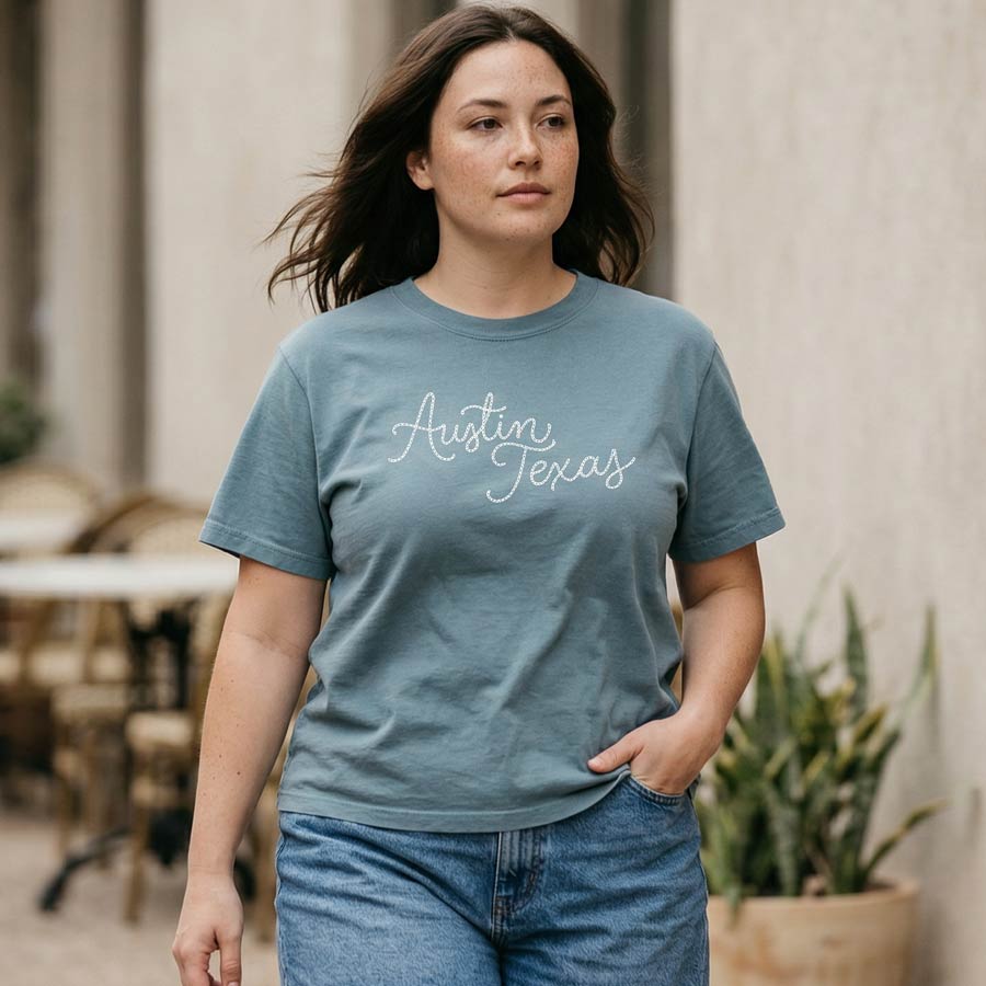 Woman wearing blue Chainstitch Austin boxy t-shirt with script design