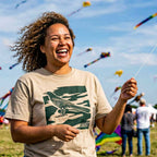 Lifestyle image of woman wearing relaxed fit garment-dyed Austin camo tee flying a kite at the Austin Kite Festival