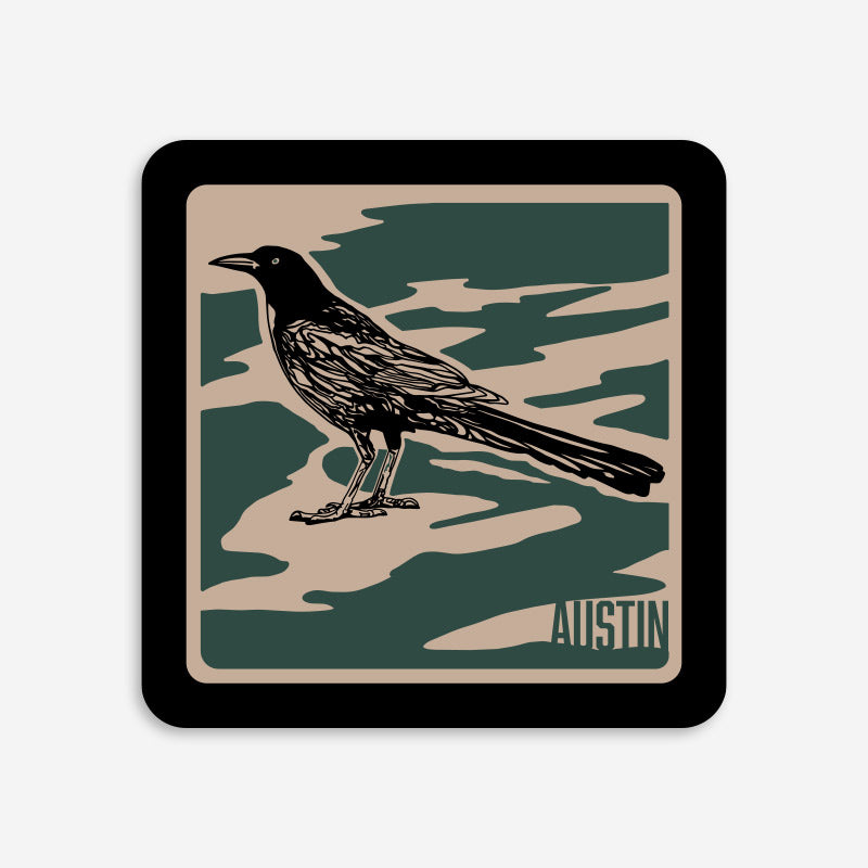 Vinyl Sticker with a grackle bird design and 'Austin' text on a camouflage pattern
