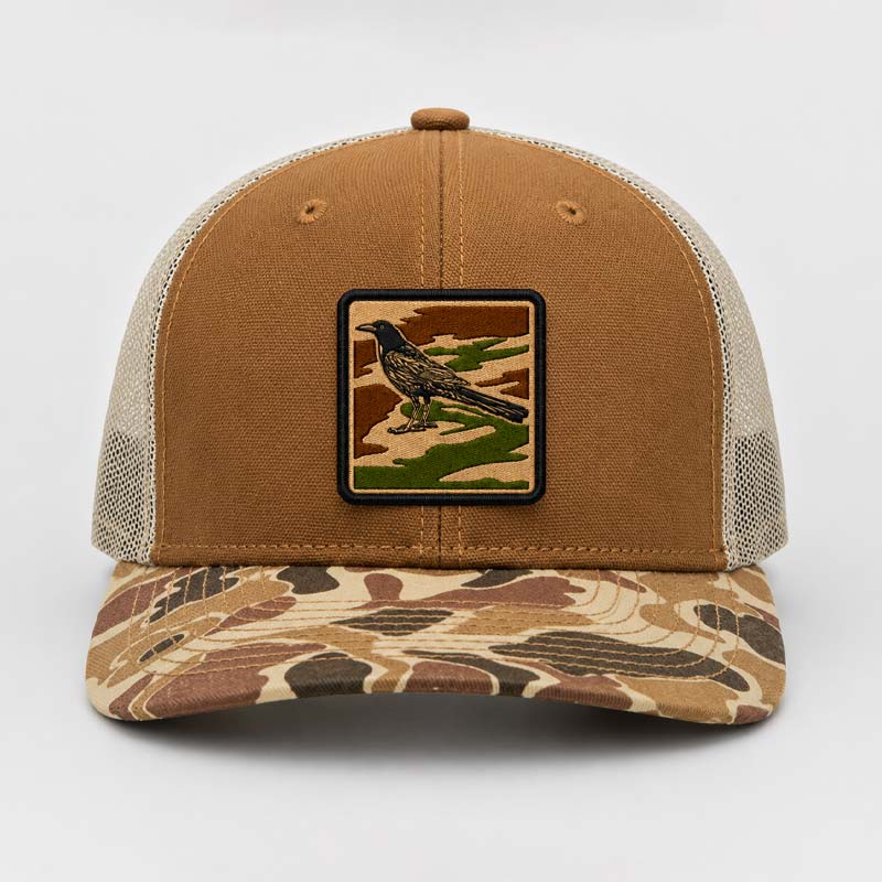Brown and beige cap with a bird patch on a white background