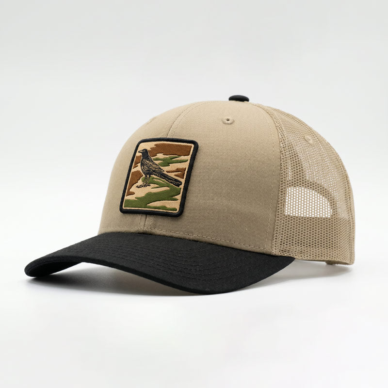 Beige and black cap with a bird patch on a white background