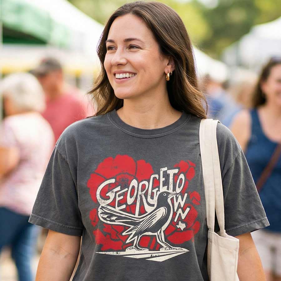 Woman wearing Texas grackle graphic tee women’s cropped boxy shirt, standing in a crowd.