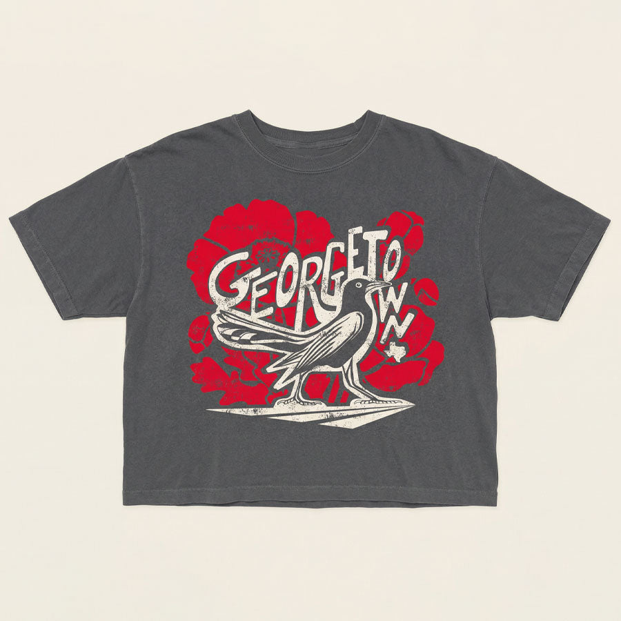 Georgetown TX grackle bird graphic shirt red poppy background women’s tee flat lay