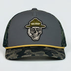 Gray and camouflage trucker hat with skull design and 'Lost Draw Provisions' logo on a white background