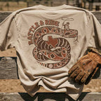 Rattle and Ride GTX Georgetown Texas graphic tee oversized tan heavyweight t-shirt Lost Draw Provisions on a wooden surface.