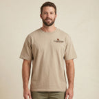 Man wearing a beige t-shirt with a logo on a beige background
