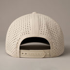 Beige baseball cap with perforated design on a beige background