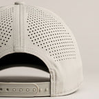 Perforated beige cap back on a putty background