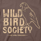 Close-up of the Wild Bird Society Tee's distressed cream bird illustration and lettering on Cocoa fabric.