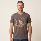Man wearing the Cocoa Wild Bird Society Tee, showing the large cream bird graphic on the front.
